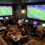 Engaging bettors analyzing odds at Luongson TV sports betting lounge during live matches.