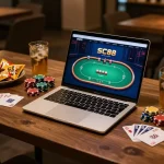 Engaging in SC88 poker gameplay on a sleek laptop surrounded by snacks, creating an inviting online gaming atmosphere.